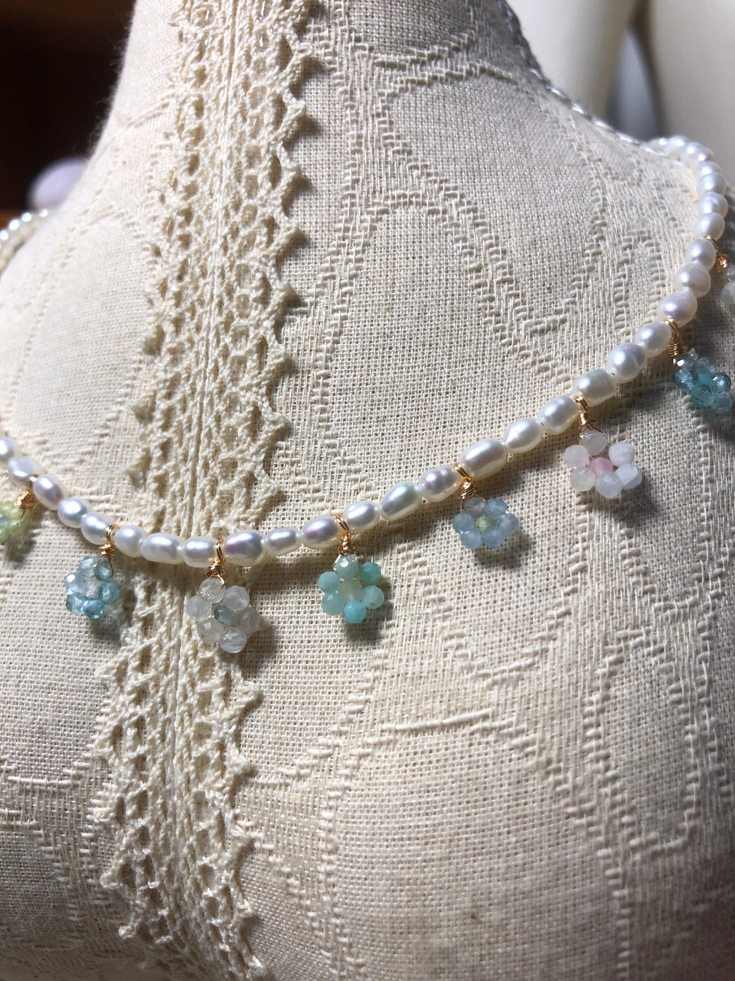 Lifestyle shot of a bohemian floral crystal and pearl necklace styled with a flowy dress, highlighting its elegant design and nature-inspired accents.