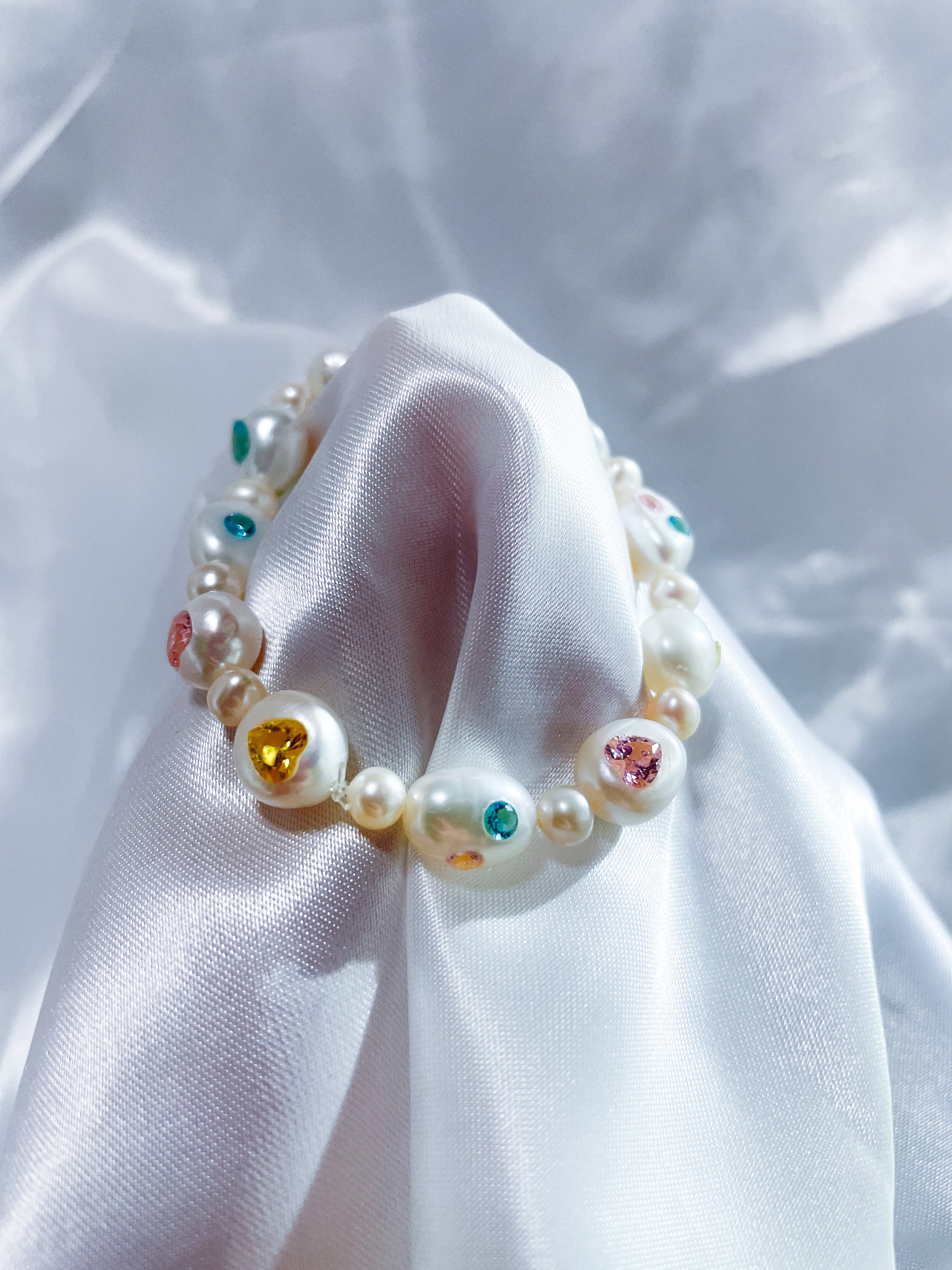 Close-up of heart-shaped yellow zircon gemstone set with luminous 8-9mm freshwater pearls