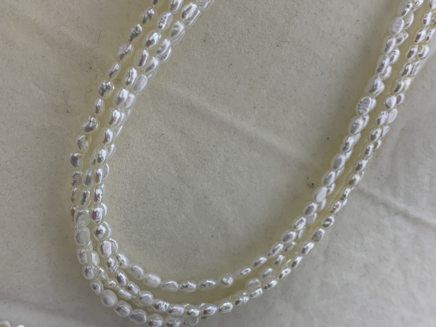 Close-up of 3-4mm freshwater pearl beads with stunning aurora colors – perfect for cultured freshwater pearl drop earrings and rings