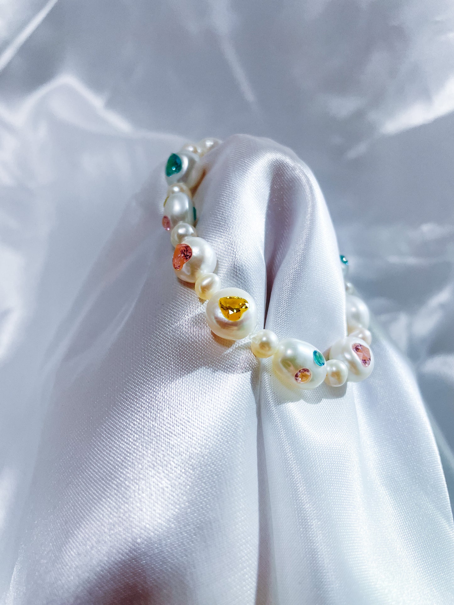 Elegant gift box presentation of a handcrafted freshwater pearl bracelet with heart-shaped zircon accents.