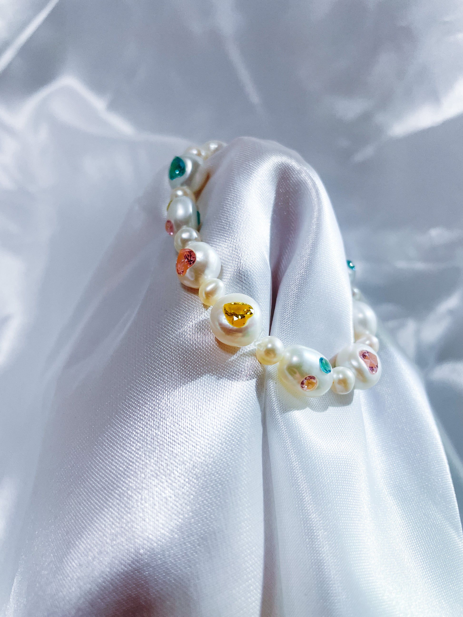 Elegant gift box presentation of a handcrafted freshwater pearl bracelet with heart-shaped zircon accents.