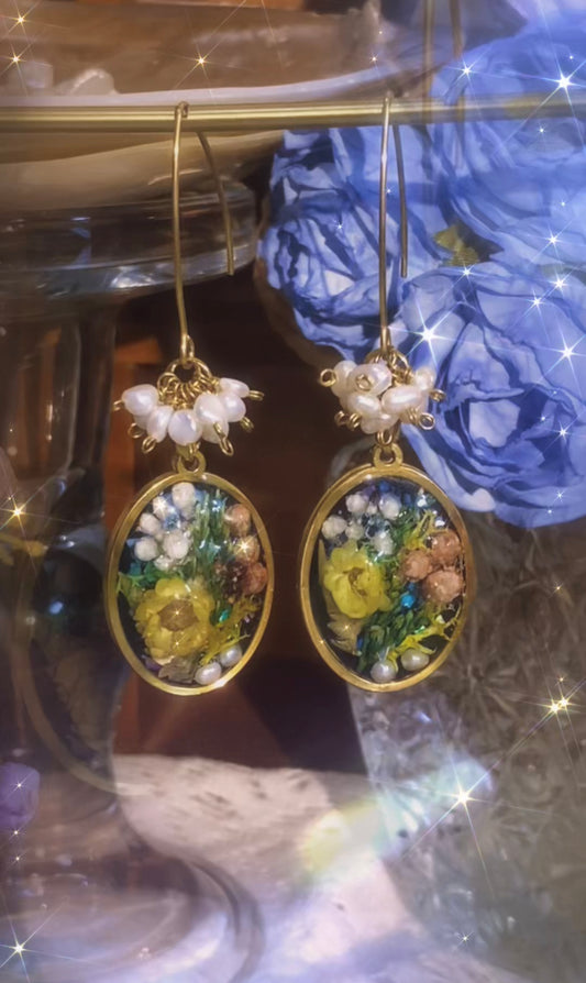 Handmade botanical-inspired earrings featuring real dried flowers preserved in resin, accented with freshwater pearls and 18K gold-plated titanium steel. Total length 7cm with a 2.8cm oval pendant.