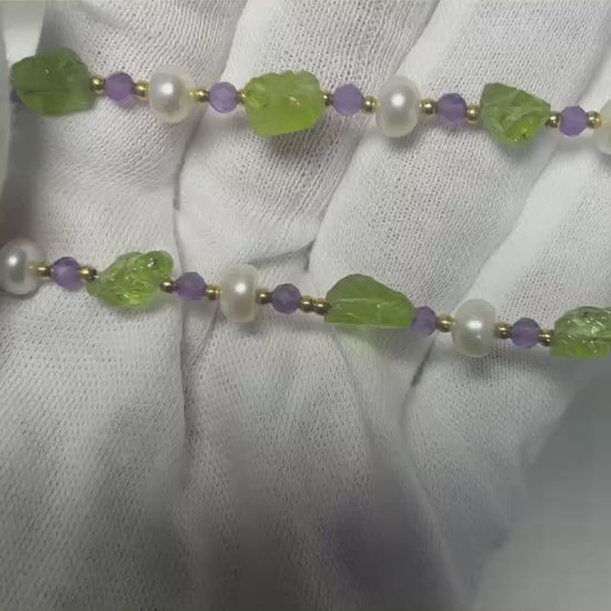 Detailed view of 18K gold-plated necklace featuring Peridot and Amethyst stones with pearl accents