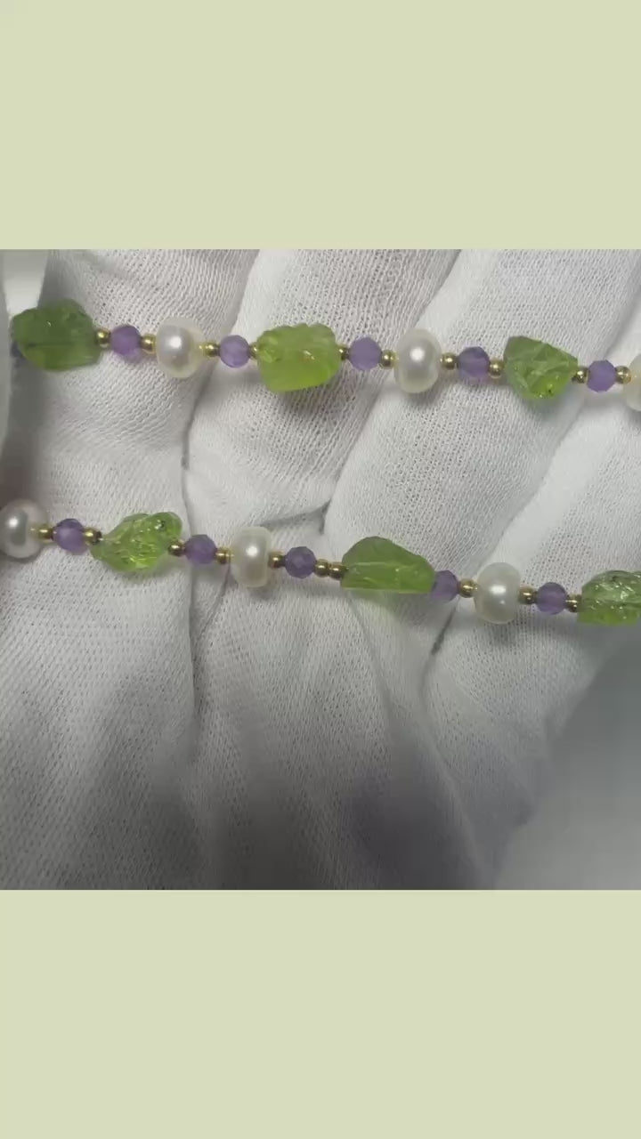 Detailed view of 18K gold-plated necklace featuring Peridot and Amethyst stones with pearl accents